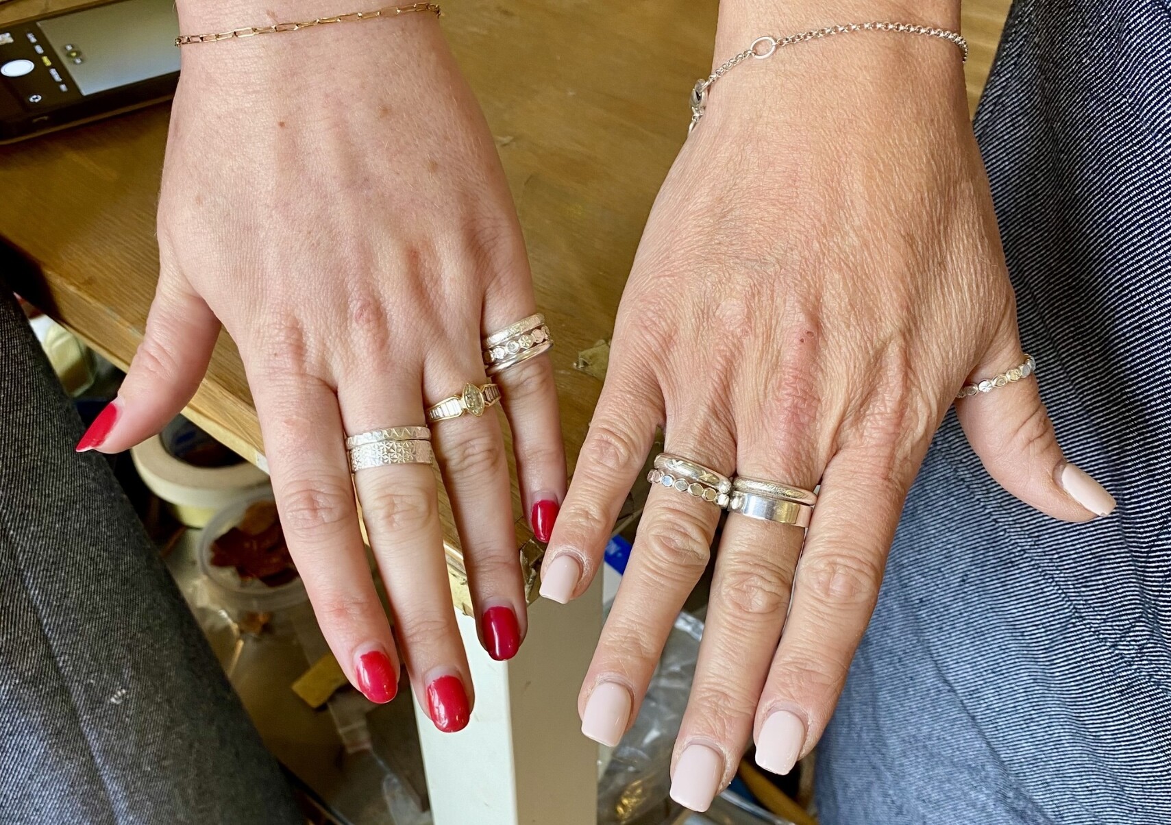 Two ladies hold out their hands showing their silver rings